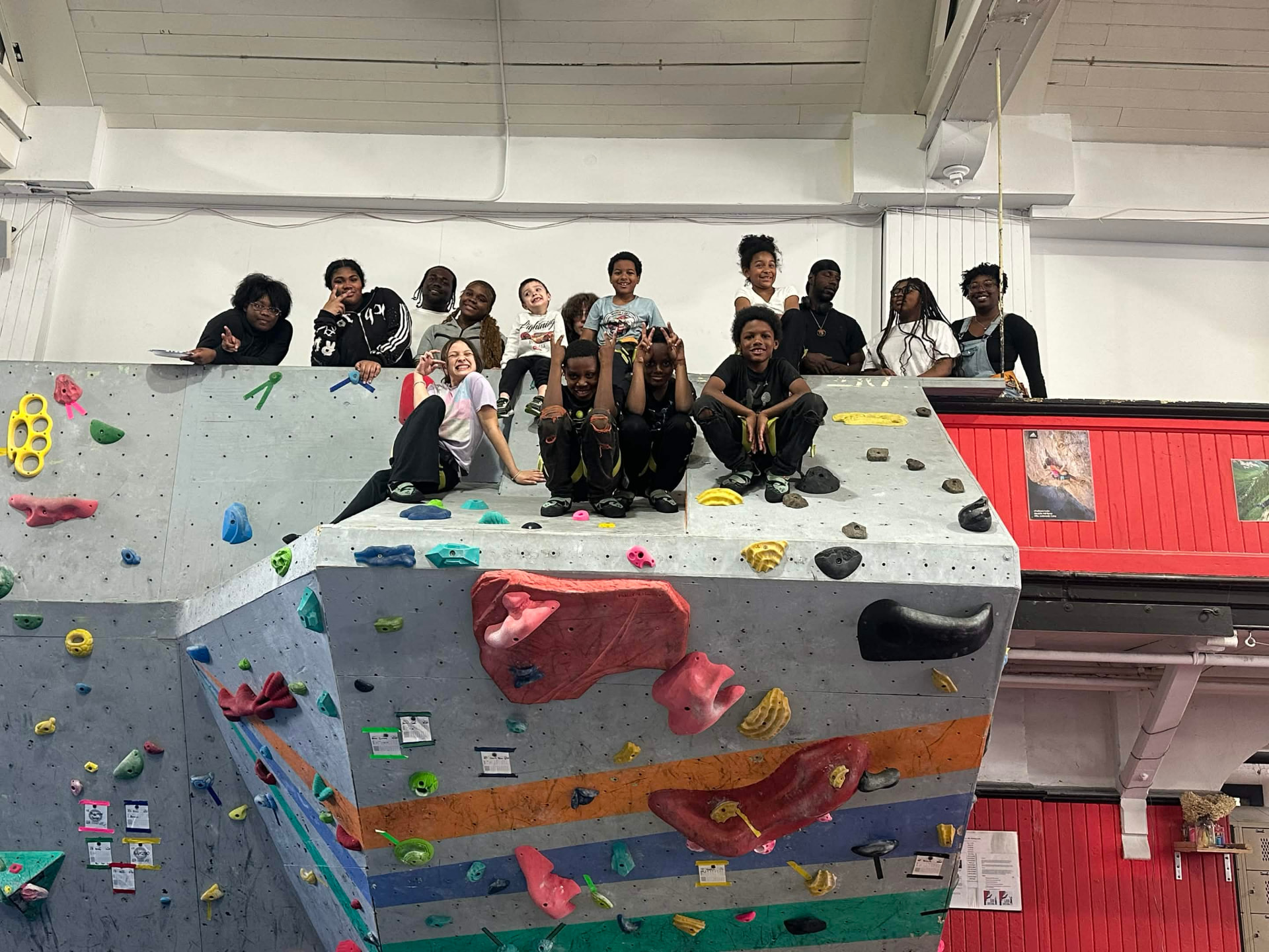 Young people, mentors, and volunteers gathered together at a Breaking Barriers Mentoring community climbing day.